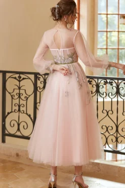Um vestido de baile de chá de luz de joia de linha nu com mangas compridas