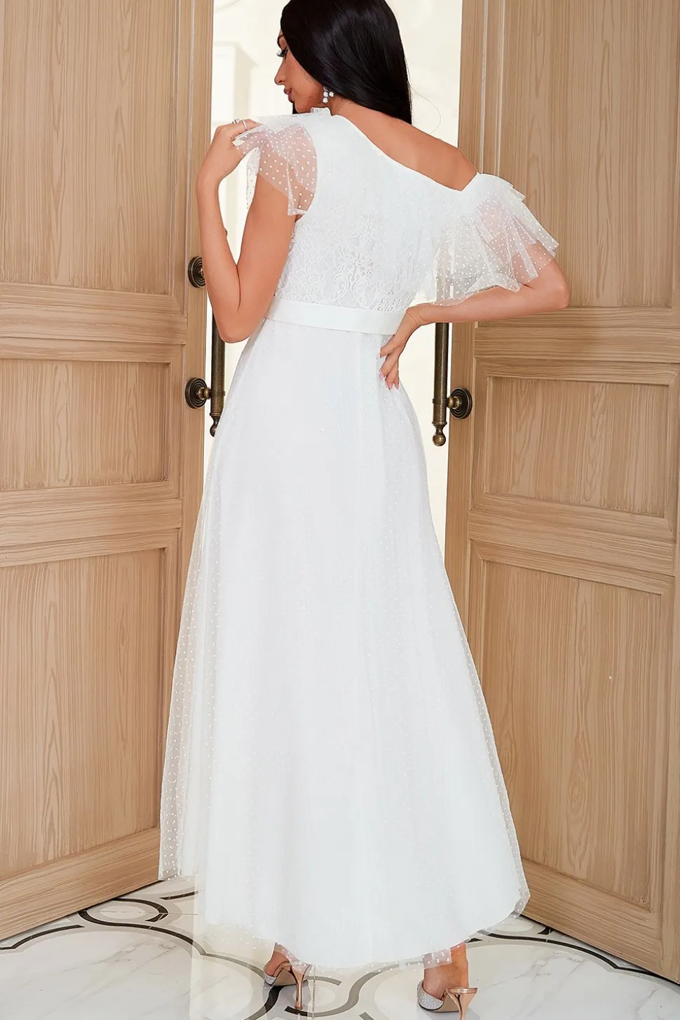 Um vestido de festa branco de ombro com fio de rede