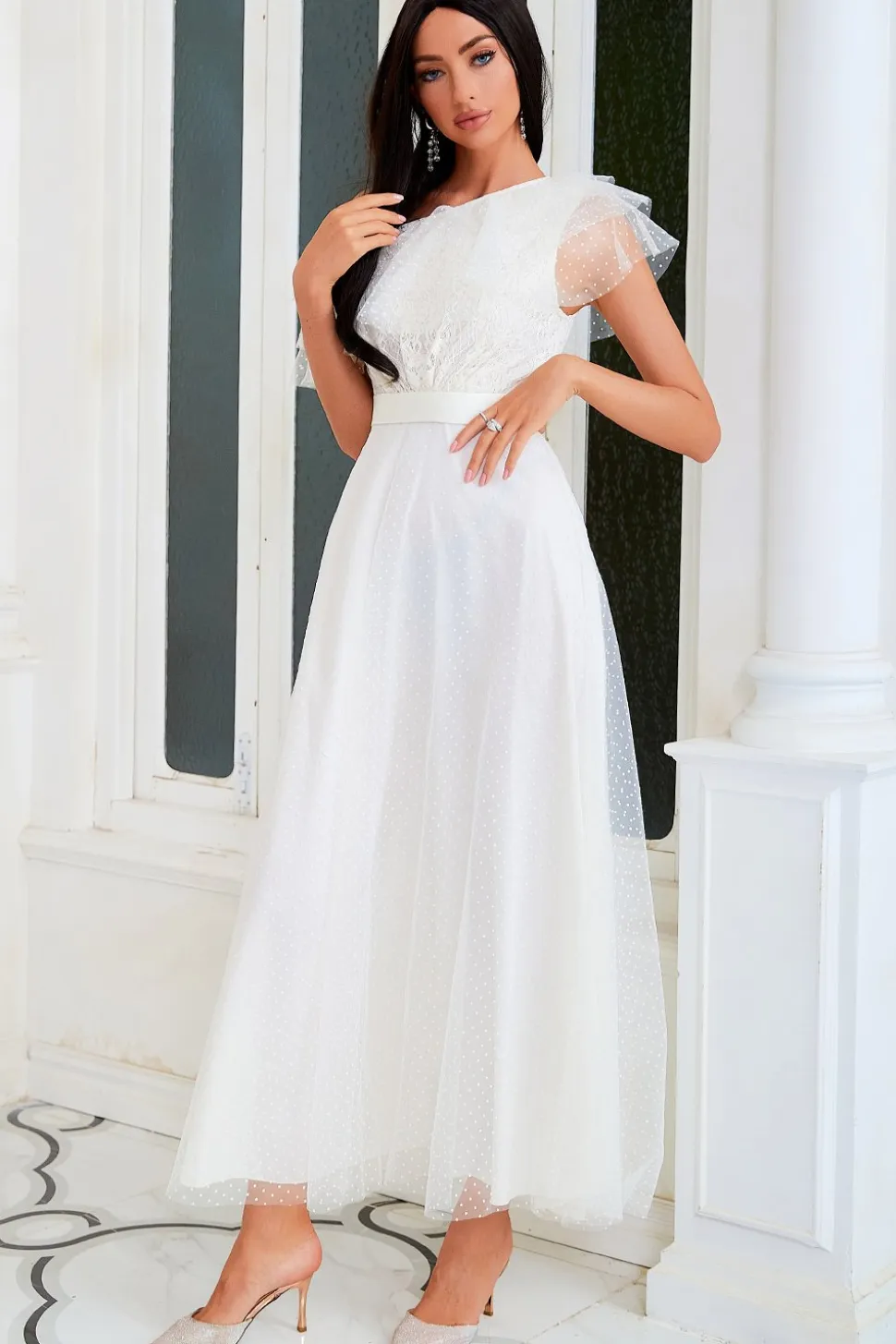 Um vestido de festa branco de ombro com fio de rede